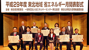 「平成29年度 東北地域 省エネルギー月間表彰式」の看板前で、受賞者たちが賞状を持つ集合写真。
