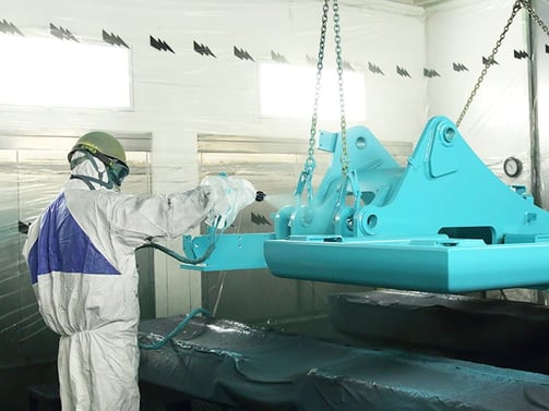 有害物質の排出量が低減された環境で塗装作業をする作業員。