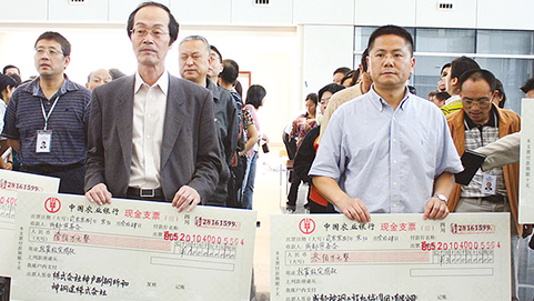 寄付金の目録を手にする関係者。