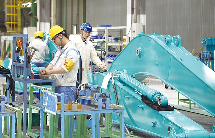 ショベルの部品を組み立てる工場の作業員。