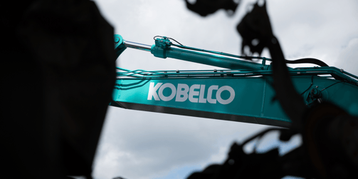コベルコ建機のターコイズグリーンの油圧ショベルのブーム部分に大きく描かれた「KOBELCO」のロゴマーク
