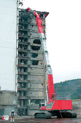 ギネス世界記録に認定されたコベルコ建機の超大型建物解体専用機SK3500D。高さ65m超の高層ビル解体シーン