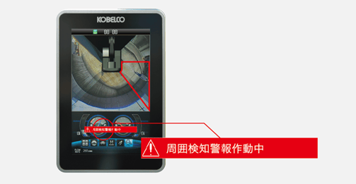 運転席の液晶モニタに「周囲検知警報作動中」と赤く表示され、検知範囲が強調された画面。