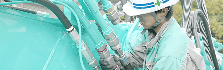 油圧ホースの接続を確認する作業員。