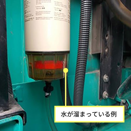 プレフィルタ底部に赤い浮きが上がり、水が溜まっている状態を示す写真。