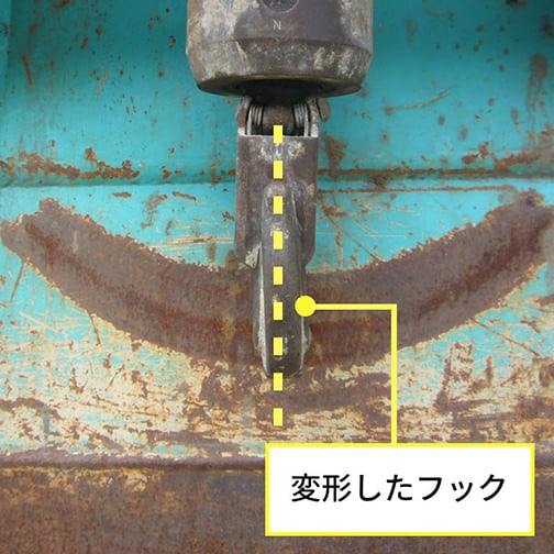 画像にマークされた基準線（点線）に対して、フックの先端が外側に開いて変形している状態を示す写真
