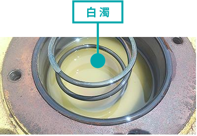 タンク内部のオイルが水分混入により白濁した、著しく劣化した状態の作動油。